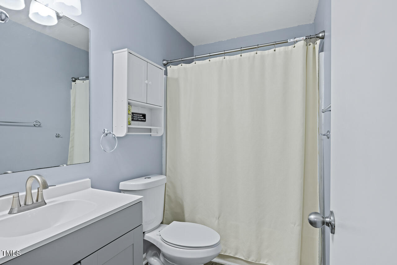 2906 Apollo Street Durham, NC 27704 - Photo 16 of 23 a white toilet sitting next to a bathroom sink