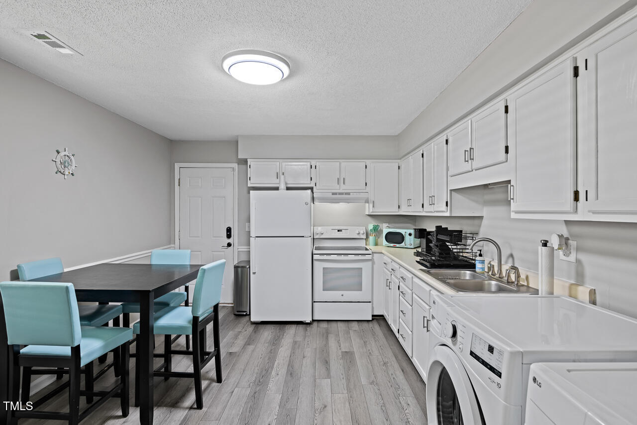 2906 Apollo Street Durham, NC 27704 - Photo 7 of 23 a kitchen with white cabinets and white appliances