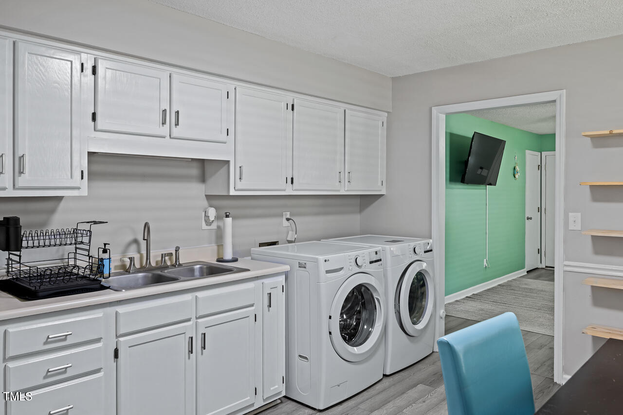 2906 Apollo Street Durham, NC 27704 - Photo 9 of 23 a kitchen with cabinets a washer and dryer