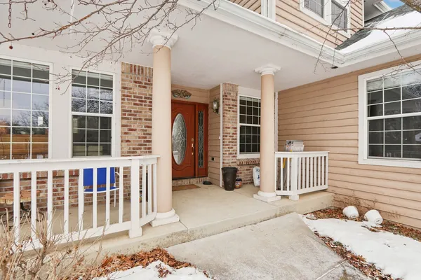 a view of a brick house with large windows and wooden fence