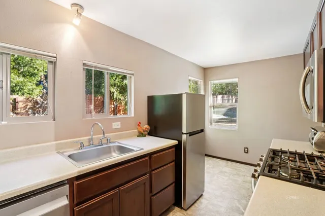 a kitchen with a sink appliances and a window