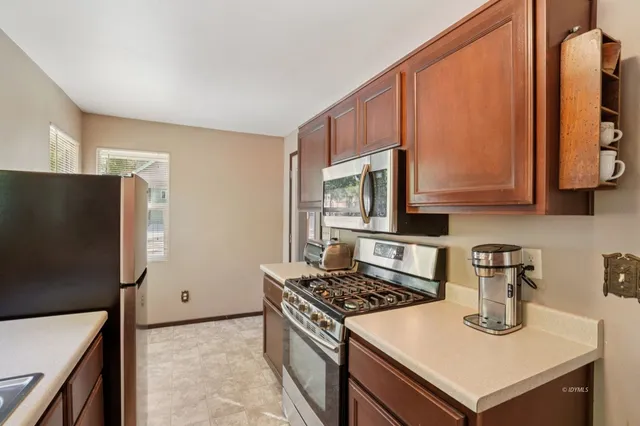 a kitchen with stainless steel appliances granite countertop a stove a refrigerator and a microwave