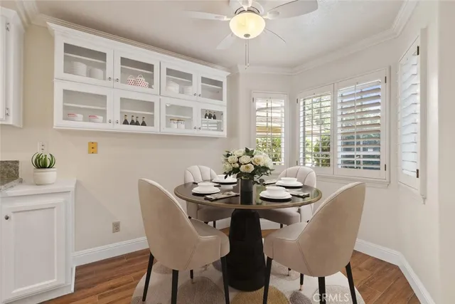 a dining room with furniture a large window and wooden floor