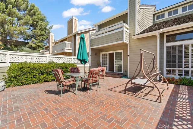 a view of a patio with couches table and chairs and potted plants