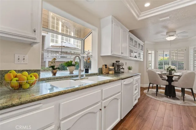 a kitchen with granite countertop a window a sink and cabinets