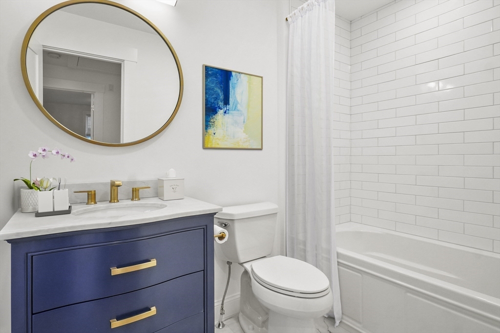 140 Main Street, Unit E Amesbury, MA 01913 - Photo 24 of 35 a bathroom with a toilet a sink a mirror and bathtub