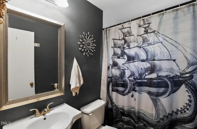 a bathroom with a sink and mirror with toilet