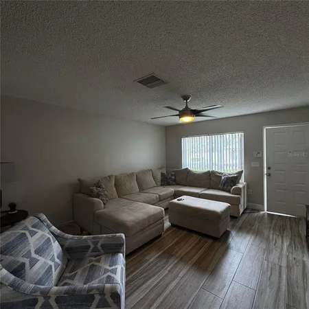 a living room with furniture and a wooden floor