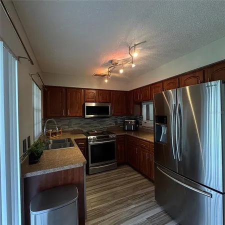 a kitchen with stainless steel appliances granite countertop a refrigerator stove microwave and sink