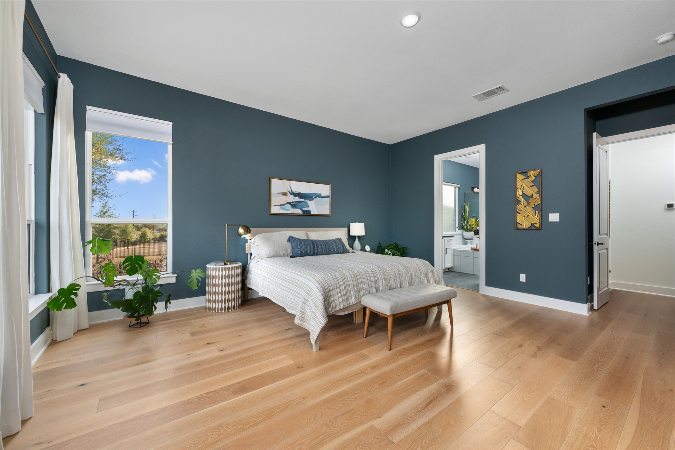 438 Pear Tree Lane Austin, TX 78737 - Photo 14 of 40 a spacious bedroom with a large bed and a potted plant