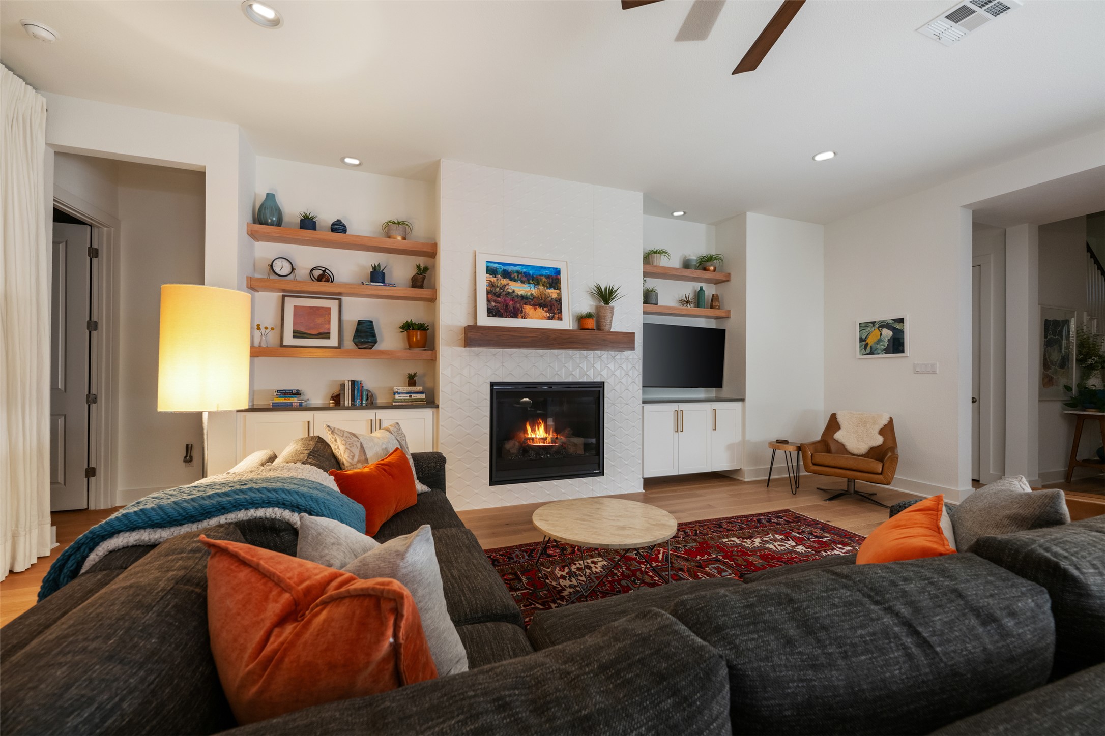 438 Pear Tree Lane Austin, TX 78737 - Photo 9 of 40 Living area featuring wood finished floors, built in features, ceiling fan, a tile fireplace, and recessed lighting