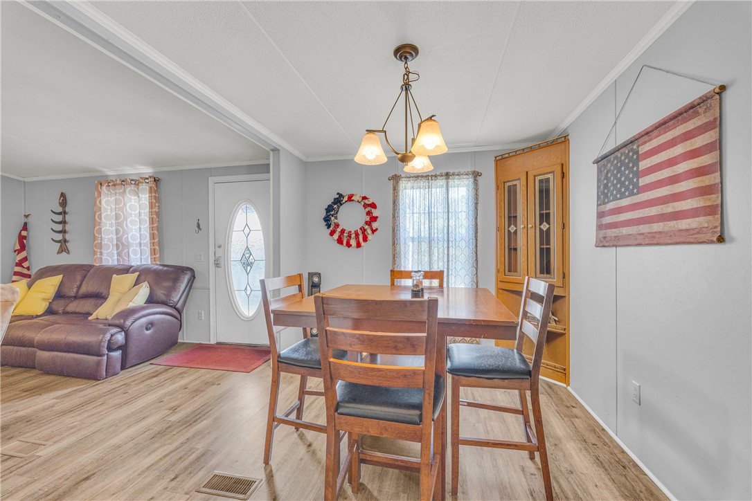 334 Lake Becky Road Mountain Rest, SC 29664 - Photo 11 of 46 A welcoming dining area offers warm wood flooring and an inviting chandelier.