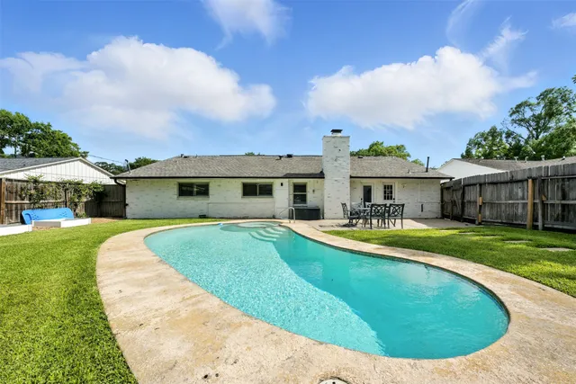 a view of a house with a swimming pool and a yard