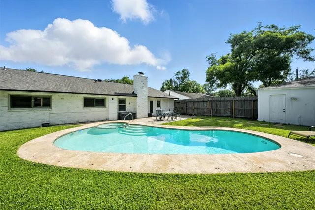 a view of a house with swimming pool and a yard