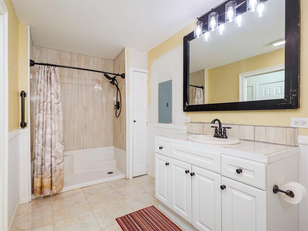 4002 Austin Avenue Brownwood, TX 76801 - Photo 14 of 34 a bathroom with a sink a shower and a mirror