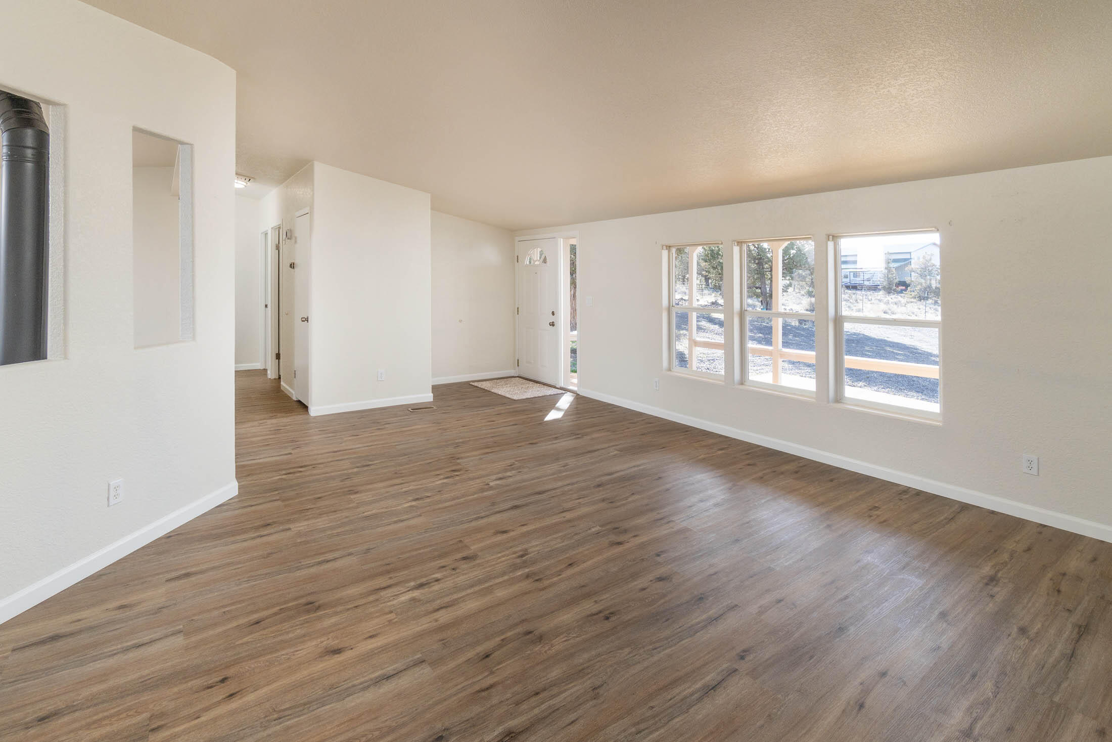 10113 Ridgeview Road Prineville, OR 97754 - Photo 12 of 31 an empty room with wooden floor and windows