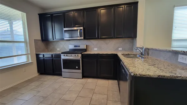 a kitchen with a stove microwave and sink