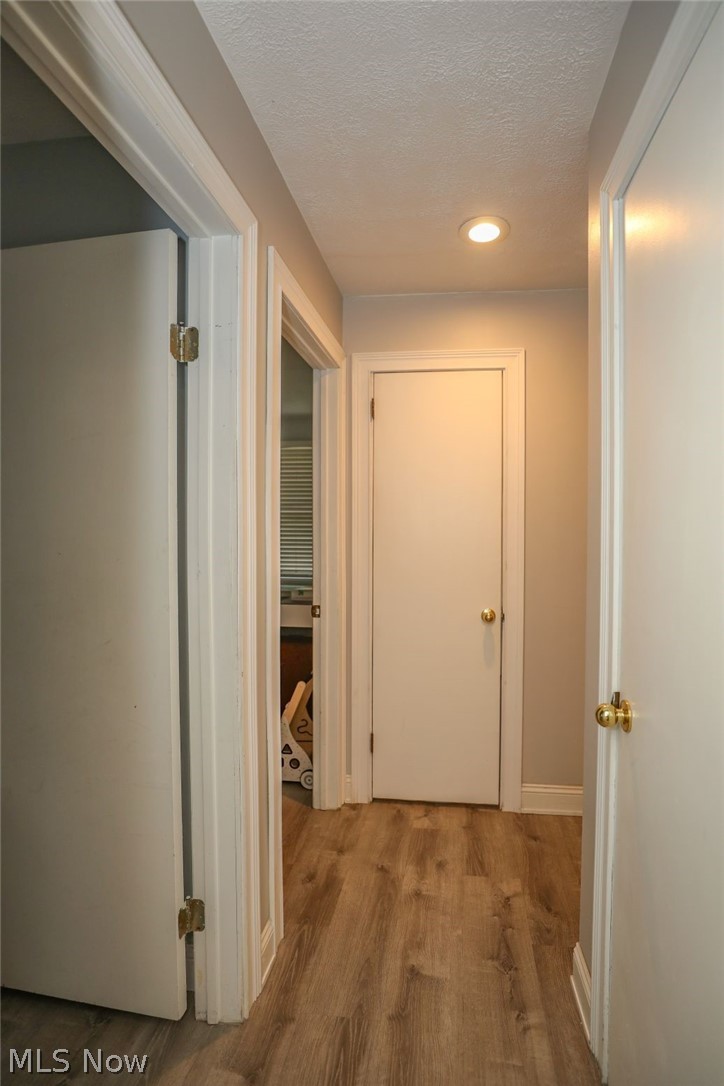 10676 Holcomb Road Newton Falls, OH 44444 - Photo 24 of 38 Corridor featuring LVT floors, a textured ceiling, and recessed lighting