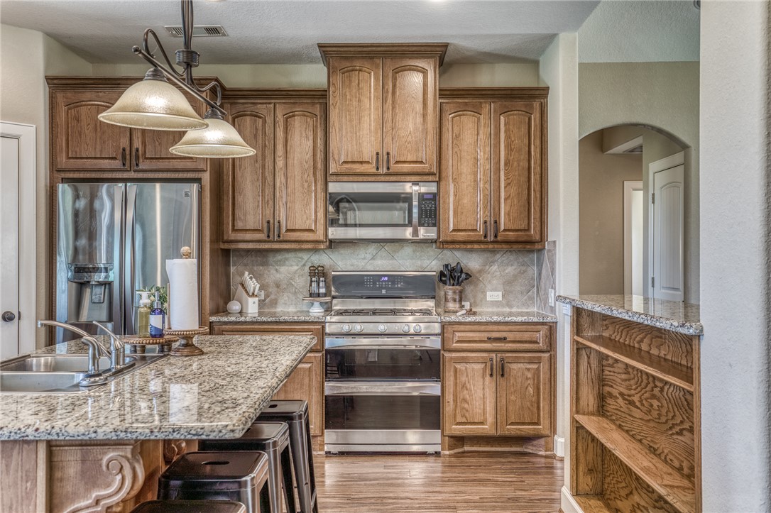 586 Ruby Drive Bellville, TX 77418 - Photo 13 of 50 a kitchen with kitchen island granite countertop a stove and a sink