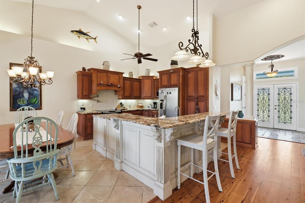 5 Palm Drive Yankeetown, FL 34498 - Photo 13 of 53 a kitchen with stainless steel appliances granite countertop a stove a sink a oven a dining table and chairs with wooden floor