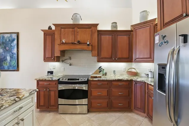 a kitchen with stainless steel appliances granite countertop a sink a stove and a refrigerator