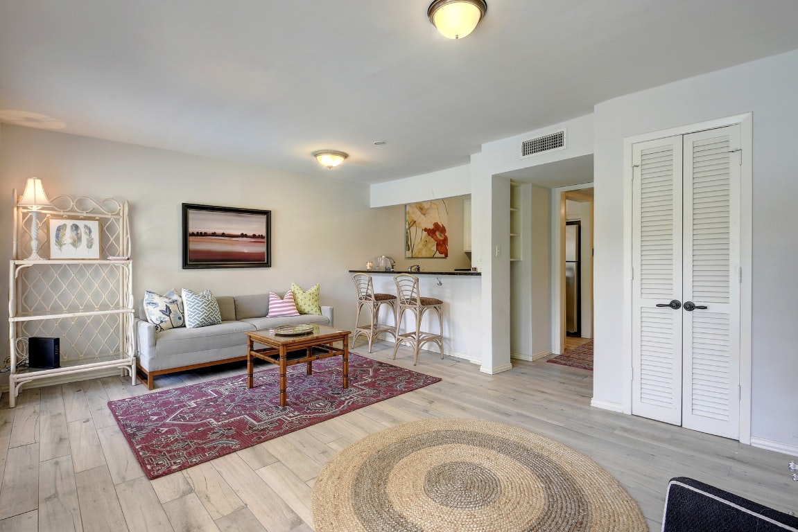 1210 Windsor Road, Unit 117 Austin, TX 78703 - Photo 1 of 17 a living room with furniture and a wooden floor