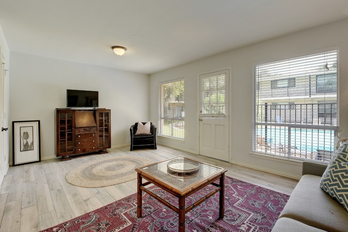 1210 Windsor Road, Unit 117 Austin, TX 78703 - Photo 2 of 17 a living room with furniture a flat screen tv and a window
