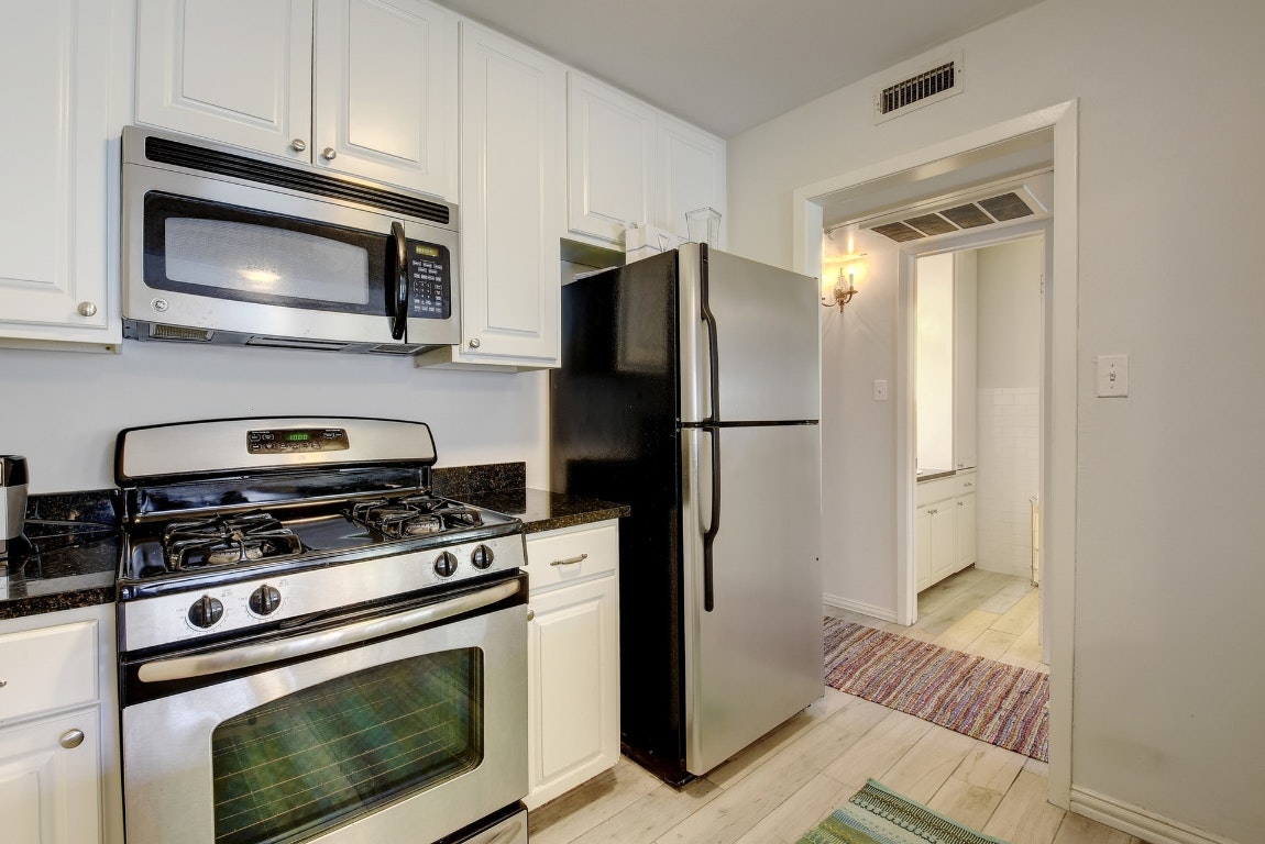 1210 Windsor Road, Unit 117 Austin, TX 78703 - Photo 4 of 17 a kitchen with a refrigerator stove and microwave