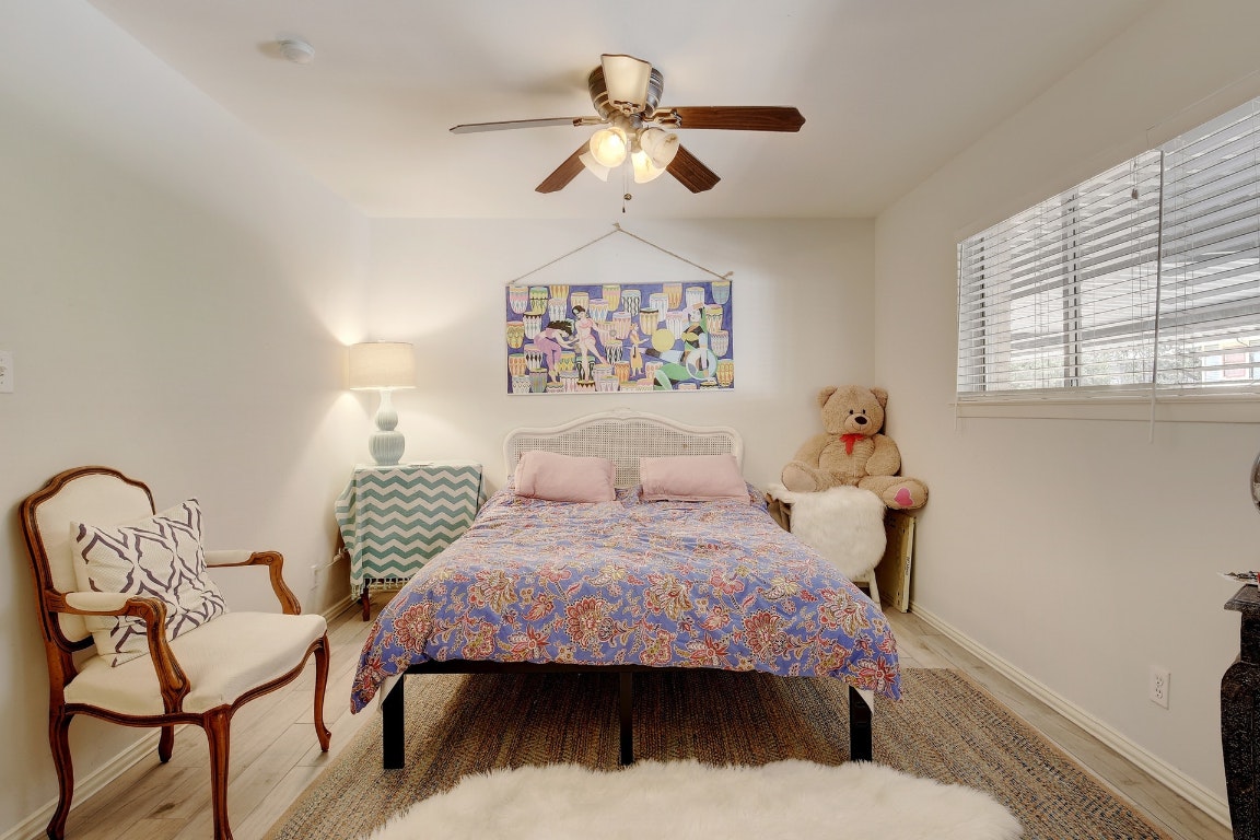 1210 Windsor Road, Unit 117 Austin, TX 78703 - Photo 8 of 17 a bedroom with a bed and a chandelier