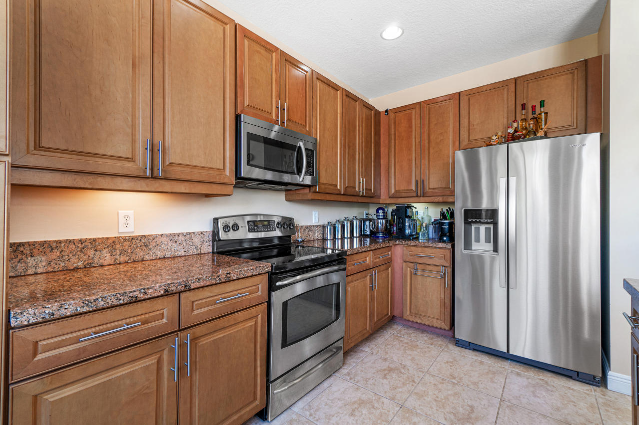 669 Northwest 38th Circle Boca Raton, FL 33431 - Photo 11 of 35 a kitchen with stainless steel appliances granite countertop a refrigerator stove top oven and sink