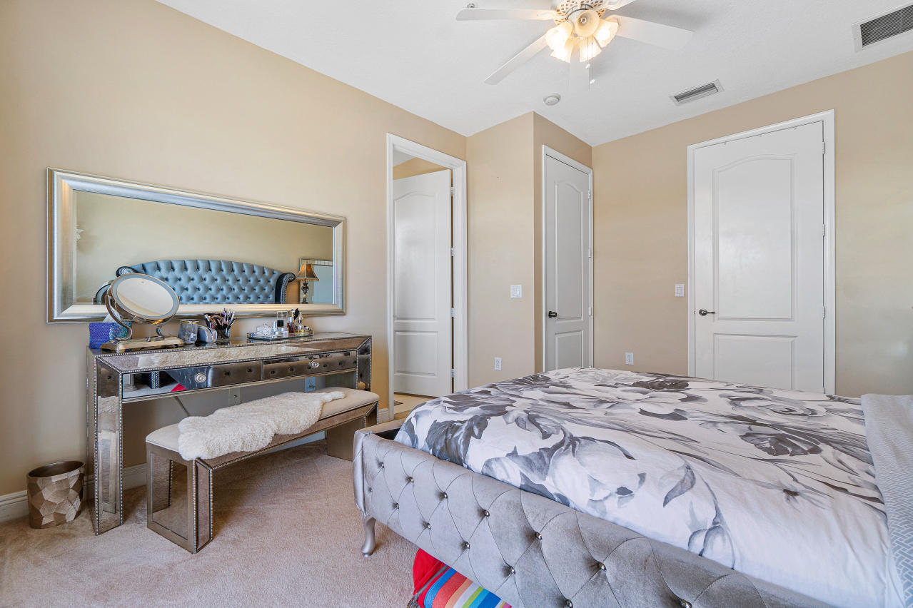 669 Northwest 38th Circle Boca Raton, FL 33431 - Photo 28 of 35 a bedroom with a bed a rug and a chandelier