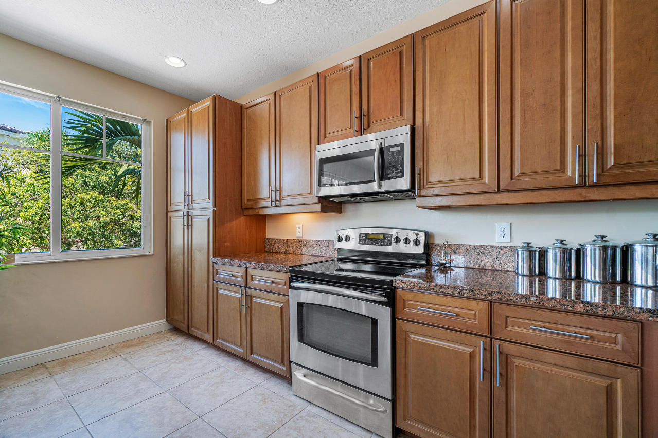 669 Northwest 38th Circle Boca Raton, FL 33431 - Photo 10 of 35 a kitchen with granite countertop wooden cabinets stainless steel appliances and a window