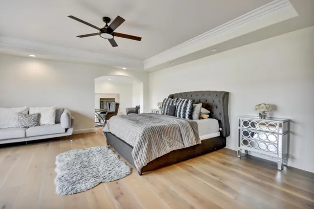 a spacious bedroom with a bed a couch and a chandelier