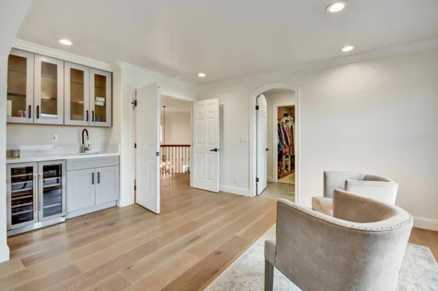 a large white kitchen with stainless steel appliances granite countertop a sink and wooden floors