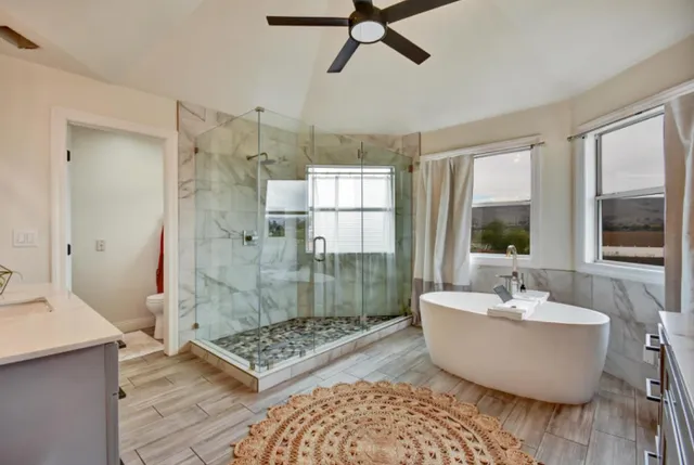 a spacious bathroom with a bathtub a window and a shower