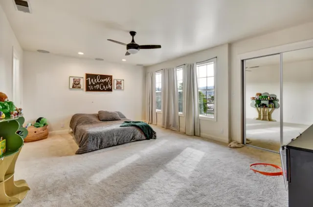 a spacious bedroom with a bed and a chandelier