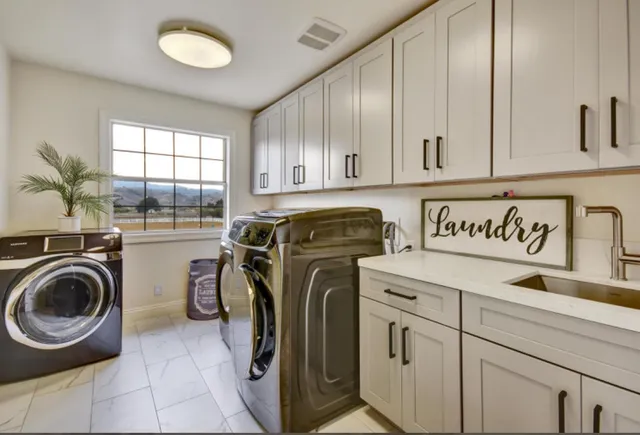 a utility room with sink dryer and washer
