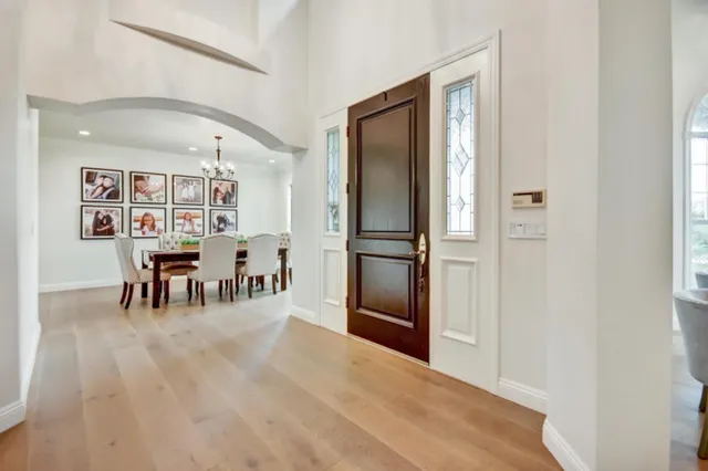 a view of a kitchen with dining area wooden floor and a refrigerator