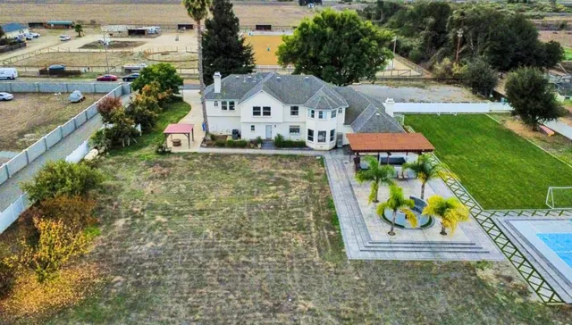 an aerial view of a residential houses with outdoor space and ocean view