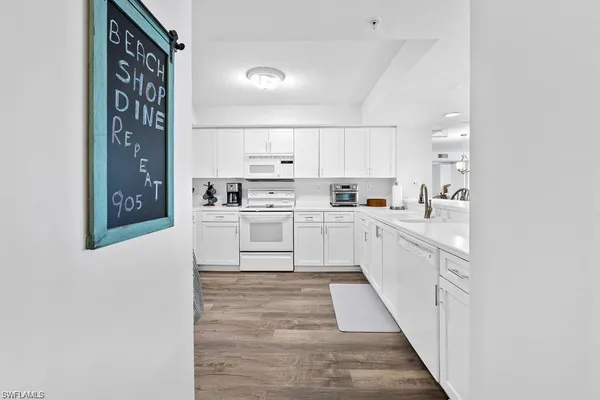 a kitchen with white cabinets and sink