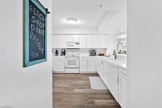 a kitchen with white cabinets and sink