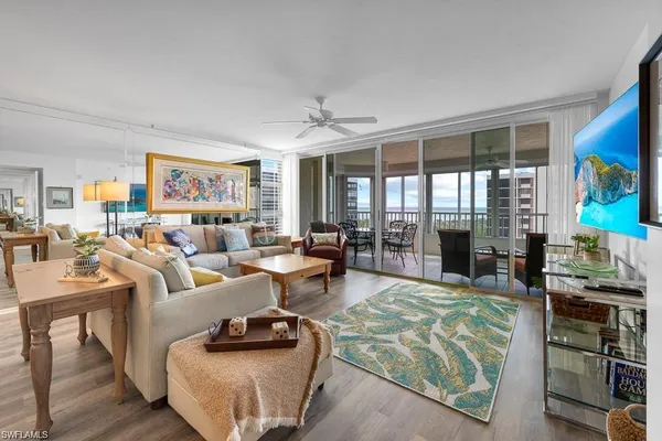 a living room with furniture a flat screen tv and a large window