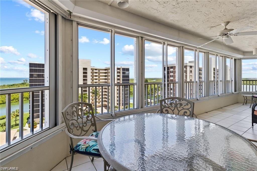 21 Bluebill Avenue, Unit B905 Naples, FL 34108 - Photo 2 of 34 a dining room with furniture large windows and wooden floor