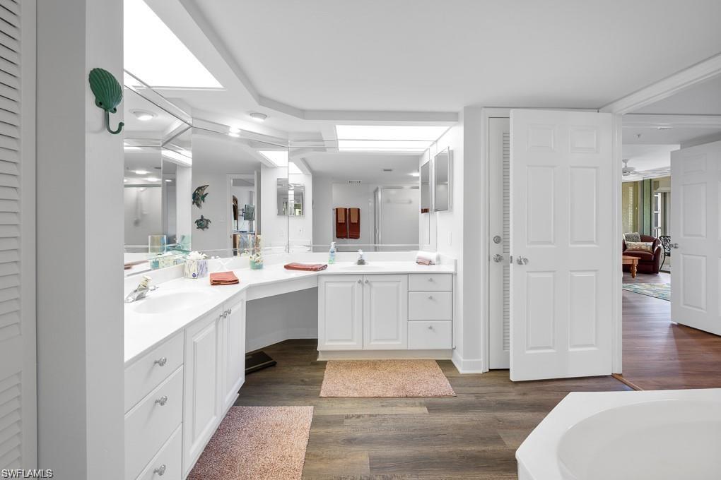 21 Bluebill Avenue, Unit B905 Naples, FL 34108 - Photo 28 of 34 a bathroom with a sink vanity and a mirror