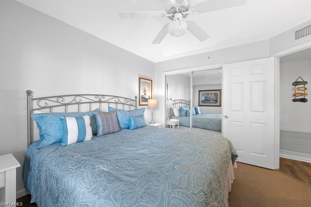21 Bluebill Avenue, Unit B905 Naples, FL 34108 - Photo 7 of 34 a bedroom with a large bed and a chandelier