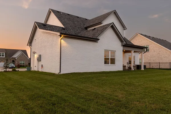 a big white house with a small yard and large trees