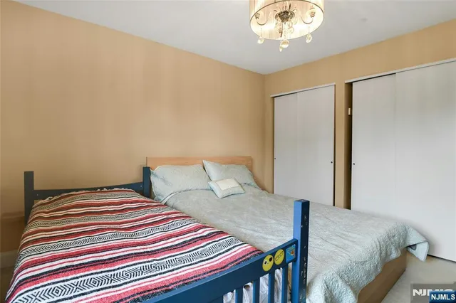 a bedroom with a bed and a chandelier