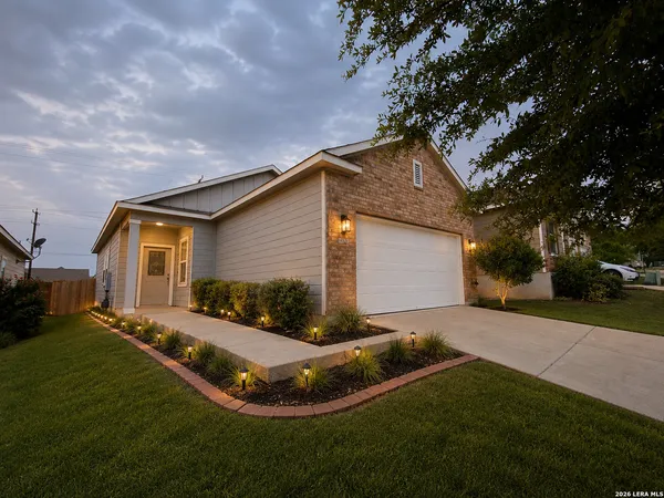 a front view of house with yard and trees around