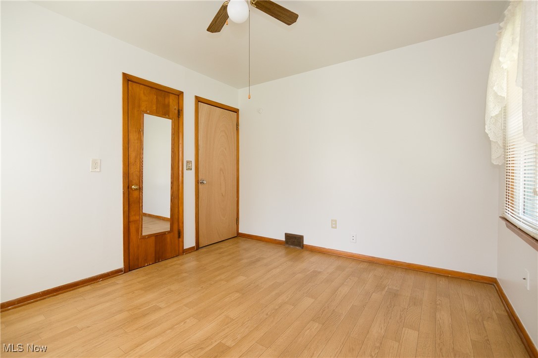 32575 Bagley Road North Ridgeville, OH 44039 - Photo 15 of 30 Unfurnished room featuring visible vents, light wood-type flooring, a ceiling fan, and baseboards