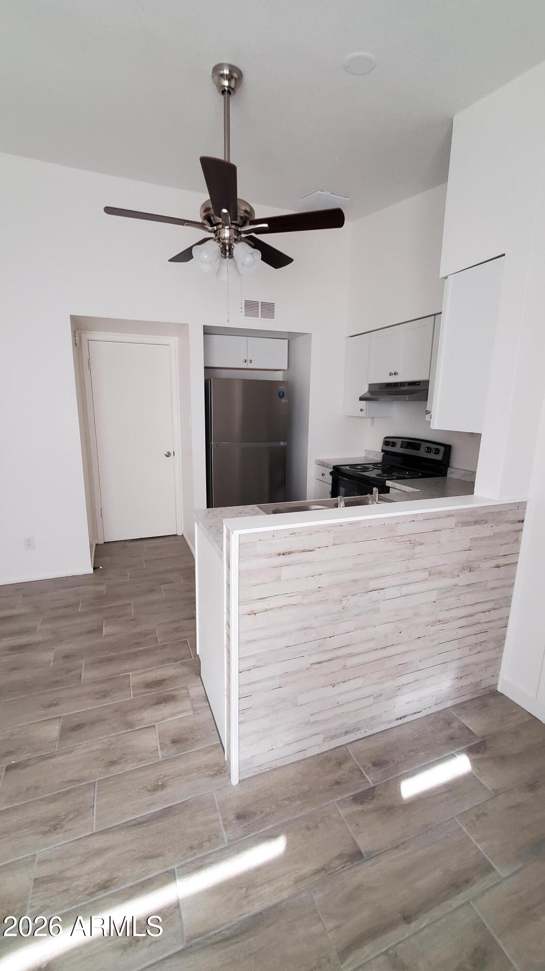 302 South Westfall Avenue, Unit 2 Tempe, AZ 85281 - Photo 3 of 19 a view of a kitchen with wooden floor and a ceiling fan